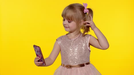 Child-girl-using-smartphone.-Portrait-of-blonde-kid-emotionally-makes-selfie-on-mobile-phone