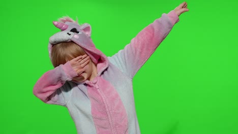 Little-blonde-child-girl-dancing,-celebrating,-performing-dab-dance-in-unicorn-pajamas-costume