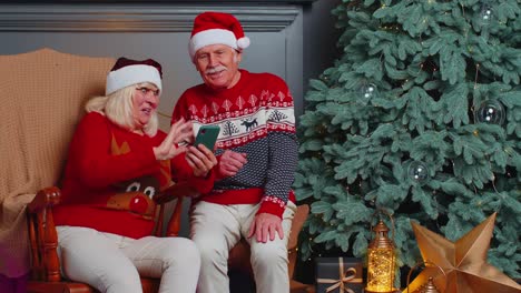 Senior-family-taking-selfie-on-mobile-phone,-communicating-video-call-online-celebrating-Christmas
