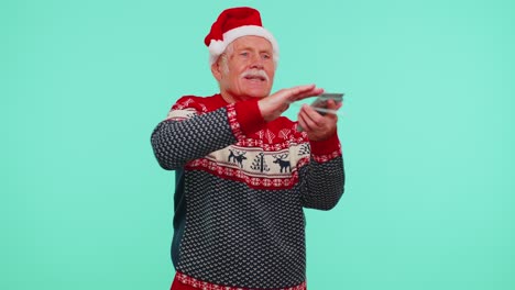 Rich-senior-man-winner-in-Christmas-red-sweater-showing-wasting,-throwing-money-around,-shopping