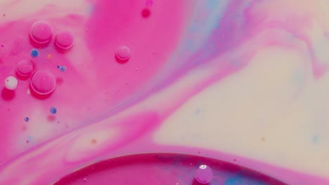Vista-Superior-Movimiento-De-Gotas-De-Tinta-De-Aceite-Rosa-Burbujas,-Fondo-De-Superficie-De-Pintura-Artística-Multicolor