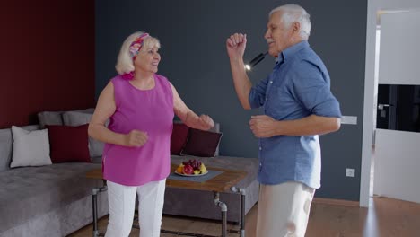 Glückliches-Altes-Seniorenpaar-Tanzt-Und-Hat-Spaß-Beim-Feiern-Des-Ruhestandsjubiläums-Im-Wohnzimmer-Zu-Hause