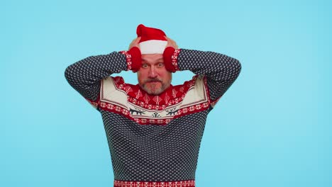 Man-wears-red-New-Year-deer-sweater-raising-hands-in-surprise-shocked-by-sudden-victory,-wow-emotion