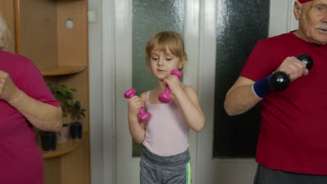 Aktives-älteres-Paar-Großmutter-Großvater-Mit-Kind-Kind-Mädchen-Macht-Fitness-Hanteln-Übungen