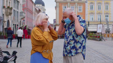 Senior-couple-tourists-grandmother-and-grandfather-wearing-medical-protective-coronavirus-mask