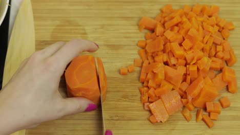 Weibliche-Hausfrau-Schneidet-In-Der-Küche-Karotten-In-Stücke