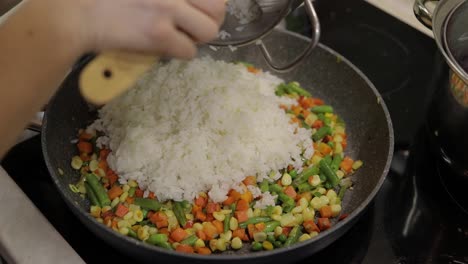 Adding-fig-to-pan-fry-meal-of-delicious-asparagus,-pepper,-corn,-carrot
