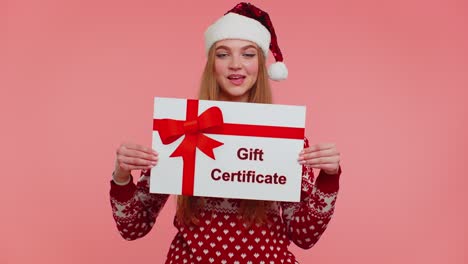 Funny-girl-wears-red-New-Year-sweater-and-hat-presenting-card-gift-certificate-coupon-winner-voucher