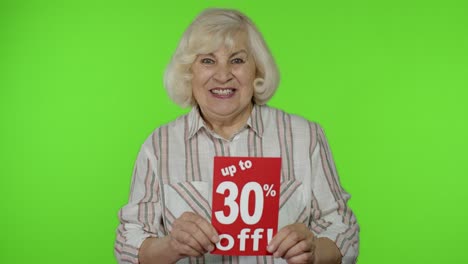 Senior-grandmother-showing-Up-To-30-percent-Off-inscription-signs,-rejoicing-discounts.-Black-Friday