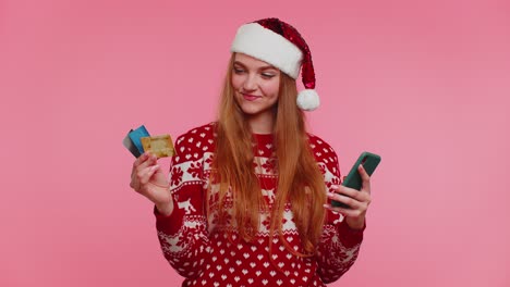 Frau-Im-Weihnachtspullover-Nutzt-Mobiltelefon-Und-Plastikkreditkarte,-Gewinnt,-Kalebiert,-Wow