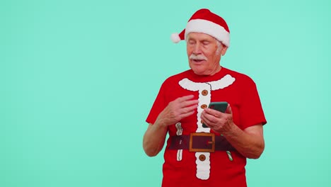 Grandfather-Santa-Christmas-t-shirt-with-mobile-phone-showing-pointing-empty-place,-advertising-area