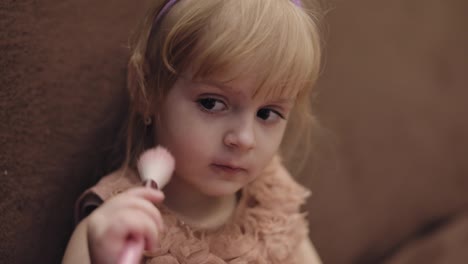 Happy-three-years-old-girl.-Cute-blonde-child.-Brown-eyes.-Girl-does-her-makeup
