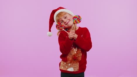 Funny-girl-in-New-Year-sweater-holding-candy-striped-lollipops-hiding-behind-them,-fooling-around