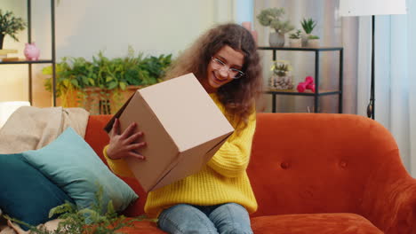 Happy-child-girl-shopper-unpacking-cardboard-box-delivery-parcel-online-shopping-purchase-at-home