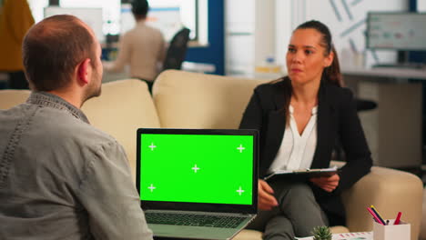 über-Der-Schulter-Des-Managers,-Der-Einen-Laptop-Mit-Grünem-Bildschirm-Hält