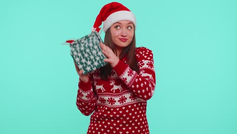 Funny-girl-wears-Christmas-holiday-sweater-received-present,-interested-in-what-inside-gift-box