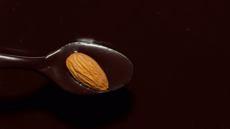 Chocolate-Negro-Líquido-Derretido-Y-Almendras-Girando,-Vista-Superior-De-Chocolate-Caliente-Líquido-Fundido