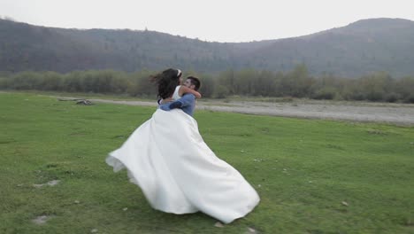 Wedding-couple-running-near-mountain-river.-Groom-and-bride-in-love