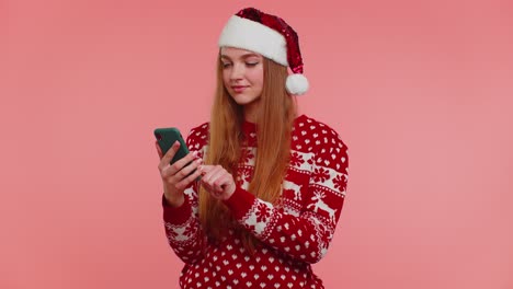 Mädchen-Im-Weihnachtspullover-Mit-Weihnachtsmann-Macht-Handyanrufe-Und-Sendet-Wünsche,-Gratuliert-Freunden-Der-Familie