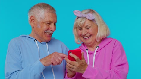 Senior-old-grandparents-pensioners-using-mobile-phone-typing-new-post,-browsing,-shopping-online