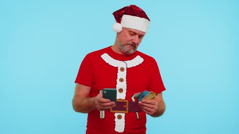 Mann-Im-Weihnachts-T-Shirt-Benutzt-Kreditkarte-Und-Smartphone,-Während-Er-Geld-Beim-Online-Einkauf-überweist