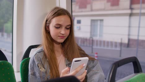 Junges-Mädchen-Nutzt-Handy-Internet-Social-Network-Anwendung-Während-Einer-Busfahrt-In-Der-Stadt