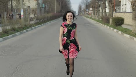 Attractive-young-woman-in-a-dress-with-flowers-running-on-the-highway