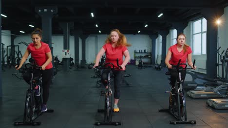 Eine-Gruppe-Von-Mädchen-Führt-Aerobic-Training,-Cardio-Training-Auf-Fahrradsimulatoren-Und-Fahrradtraining-Durch