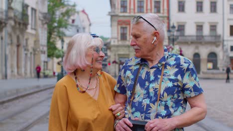 Elderly-stylish-couple-tourists-man-and-woman-enjoying-conversation-on-street-in-city-Lviv,-Ukraine