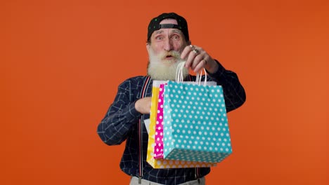 Elderly-bearded-man-showing-Sale-inscription-banner-text,-advertising-discounts,-low-holidays-prices