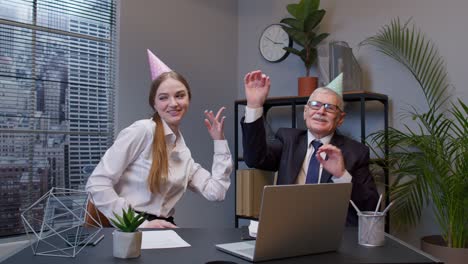 Smiling-secretary-with-handsome-senior-businessman-company-director-dancing-victory-dance-in-office