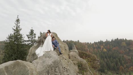 Newlyweds-stand-on-a-high-slope-of-the-mountain.-Groom-and-bride