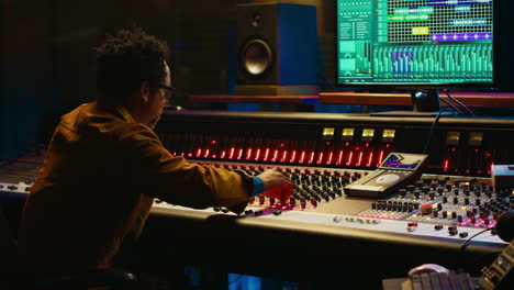 African-american-audio-expert-adding-sound-effects-on-tracks-in-post-production
