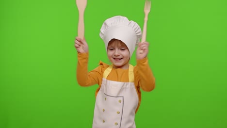 Funny-child-girl-kid-dressed-cook-chef-baker-in-apron-and-hat-dancing,-fooling-around,-making-faces
