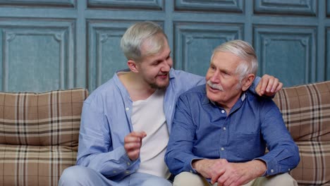 Family-of-senior-father-and-adult-son-man-or-grandson-having-heart-to-heart-conversation-at-home