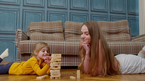 Glückliche-Junge-Mutter-Frau-Lehrt-Kleine-Tochter-Spielen-Holzklötze-Brettspiel-Zu-Hause