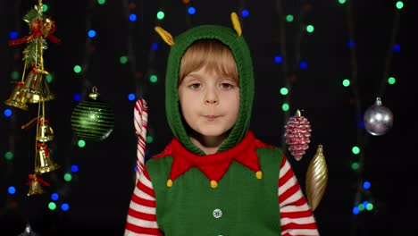 Kid-girl-in-Christmas-elf-Santa-helper-costume-dancing,-fooling-around.-New-Year-holiday-celebration