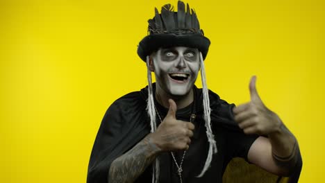 Frightening-man-in-skeleton-Halloween-cosplay-makeup-looking-at-camera,-showning-thumbs-up-gesture
