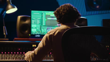 Sound-designer-mixing-and-mastering-tracks-on-audio-console-in-control-room