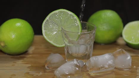 Pour-vodka-or-tequila-into-shot-glasses-with-ice-cubes
