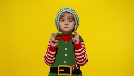 Christmas-wish-concept.-Kid-teen-girl-in-Christmas-elf-Santa-helper-costume-making-a-wish,-prays