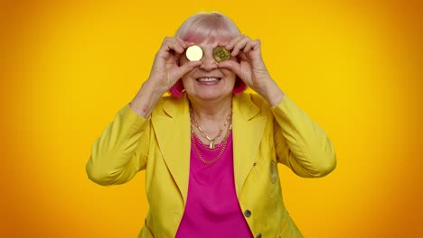 Senior-old-stylish-granny-woman-showing-golden-bitcoins,-cryptocurrency-investment-mining-technology