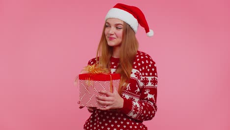 Chica-Alegre-Con-Suéter-Rojo-De-Navidad-Con-Ciervos-Presentando-Caja-De-Regalo-De-Navidad,-Venta-De-Compras-Navideñas