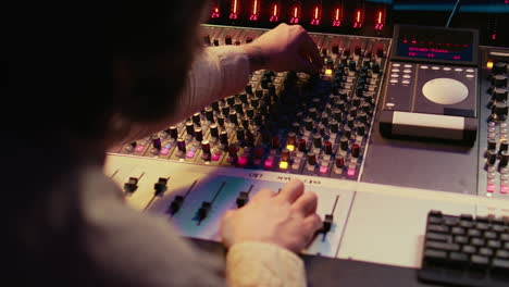 Male-producer-working-at-mixing-panel-in-the-professional-recording-studio
