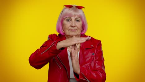 Anciana-Y-Elegante-Abuela-Rockera-Con-Cabello-Rosado-Mostrando-Gesto-De-Tiempo-De-Espera,-Límite-O-Señal-De-Stop