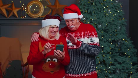 Mature-family-taking-selfie-on-mobile-phone,-communicating-video-call-online-celebrating-Christmas