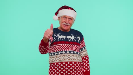 Grandfather-wears-red-New-Year-sweater-with-deers-raises-thumbs-up-agrees-with-something-good,-like