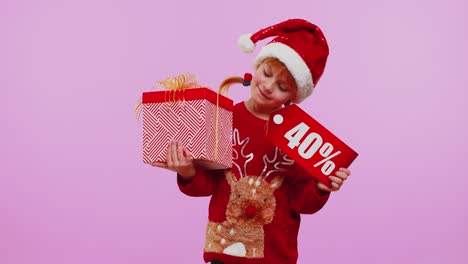 Toddler-girl-in-Christmas-hat-showing-gift-box-and-40-Percent-discount-inscriptions-banner-note-text