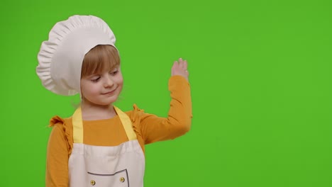 Child-girl-dressed-like-chef-cook-pointing-at-right-on-blank-space-place-for-your-advertisement-logo