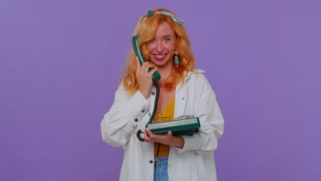 Cheerful-redhead-girl-secretary-talking-on-wired-vintage-telephone-of-80s,-says-hey-you-call-me-back